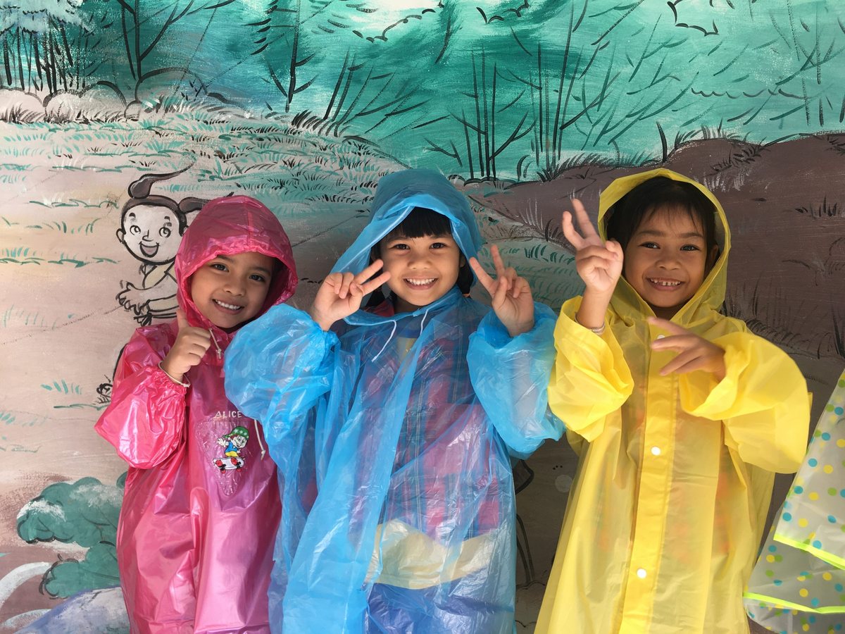 Students wearing colorful raincoats during an activity